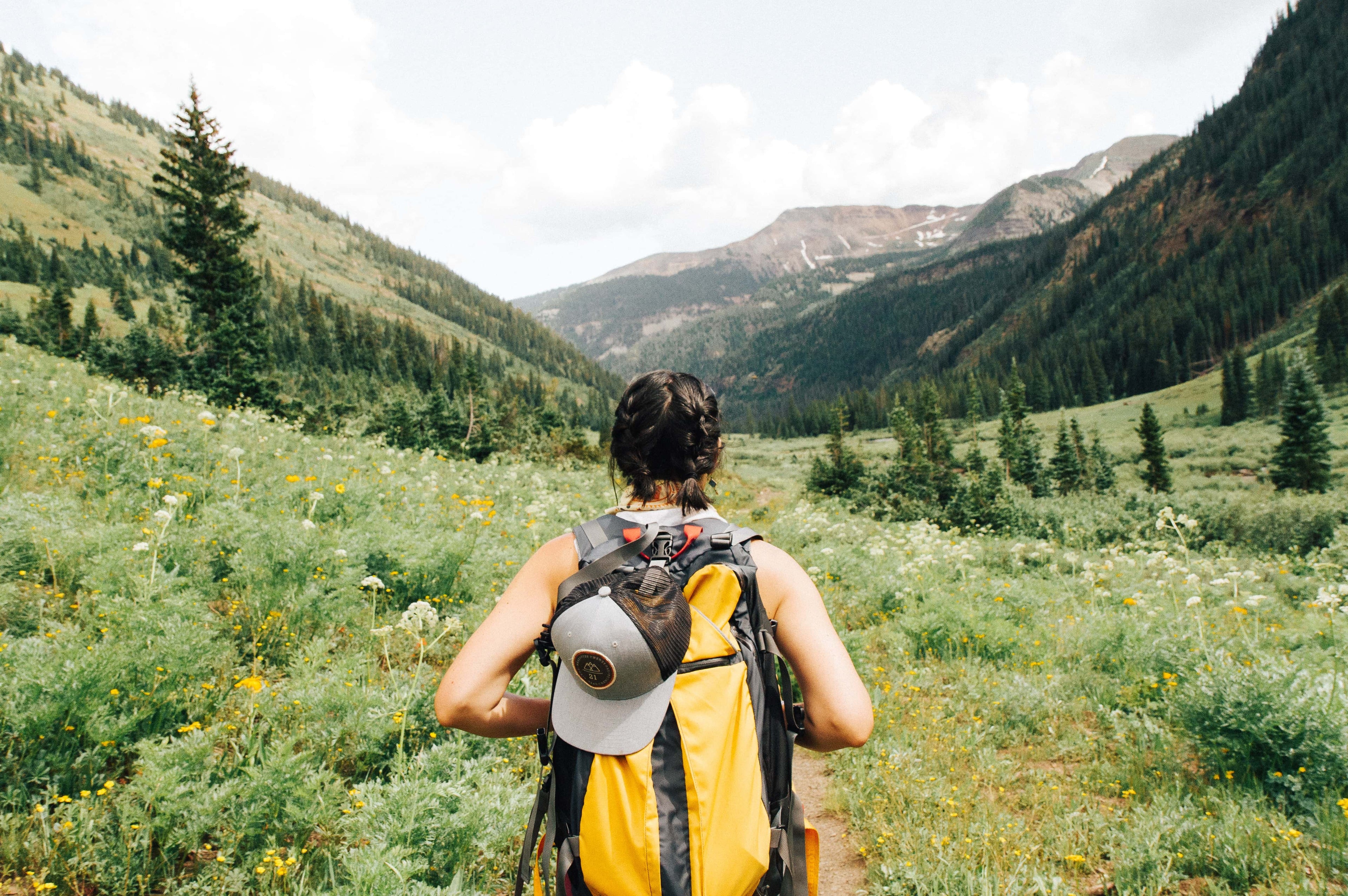 woman hiking in a green valley