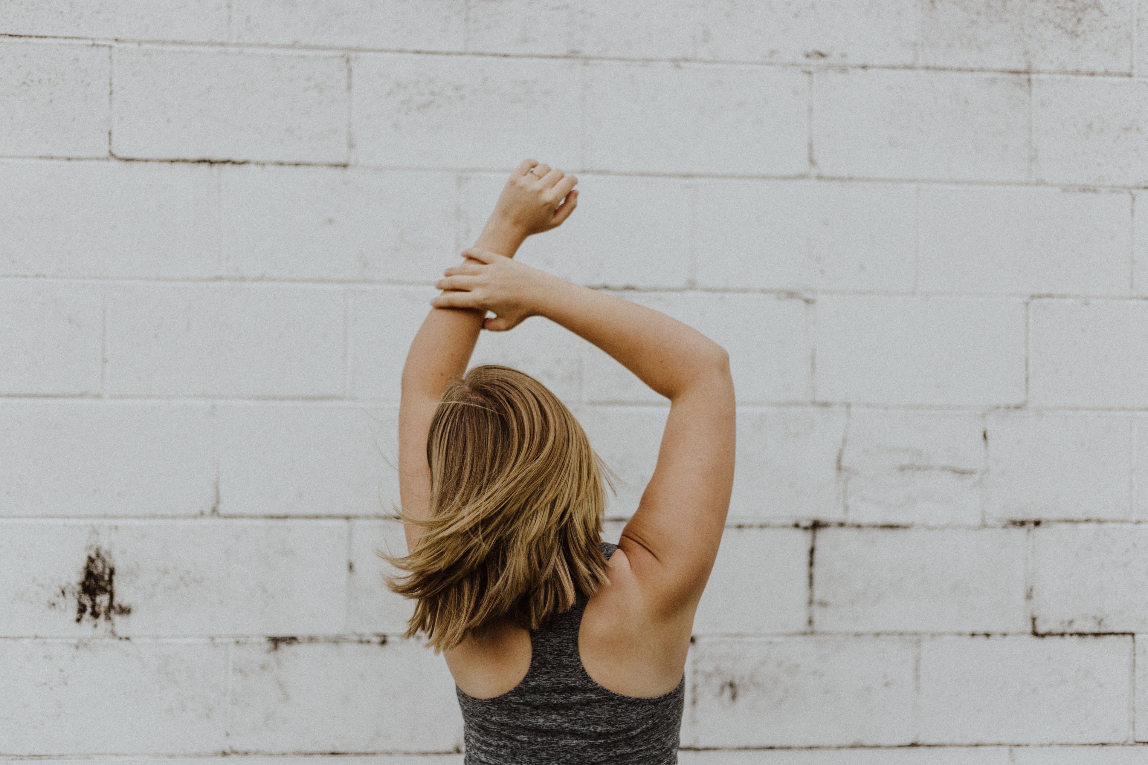 woman facing a wall holding her hand in the air