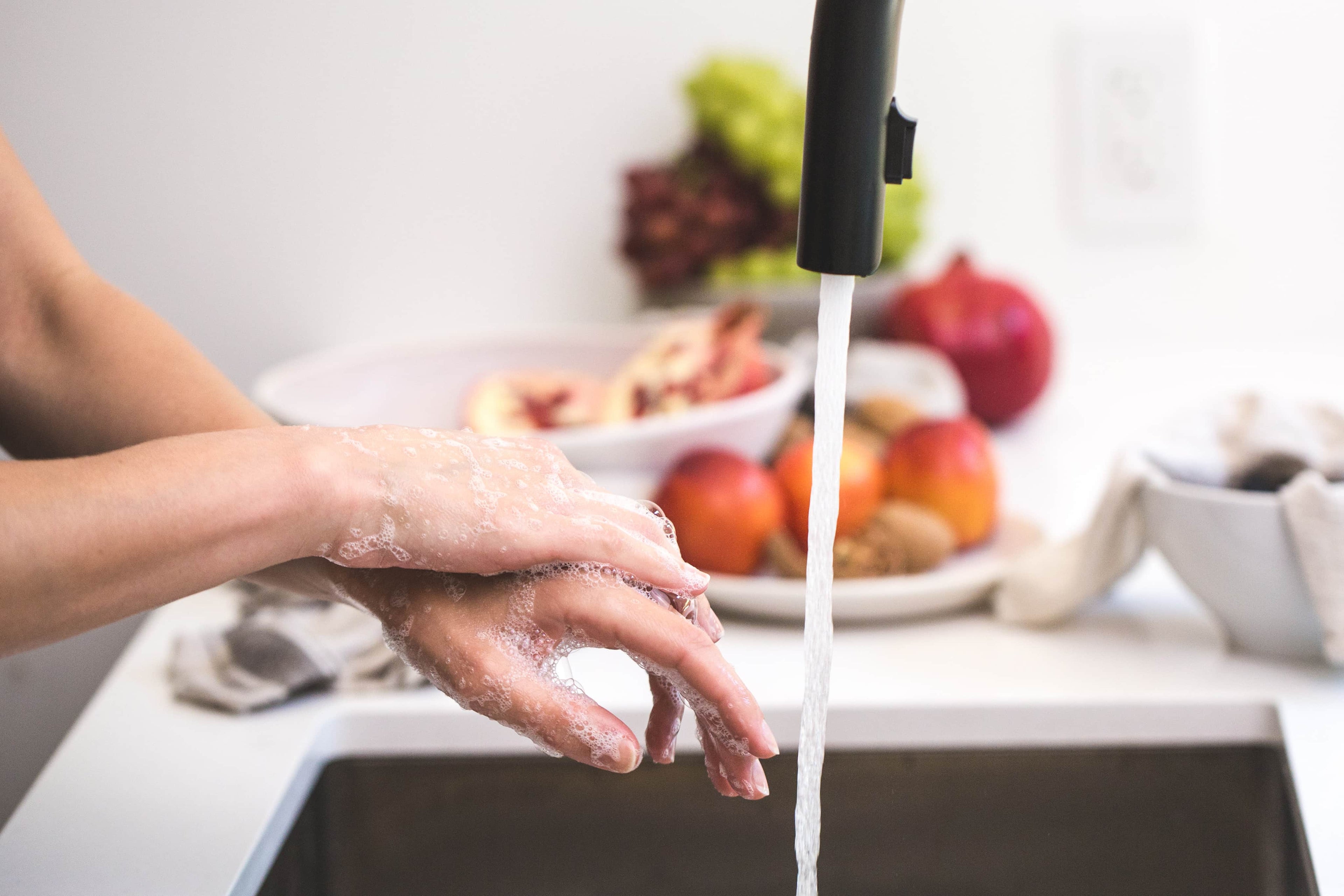Woman washing her hands in the kitchen sink